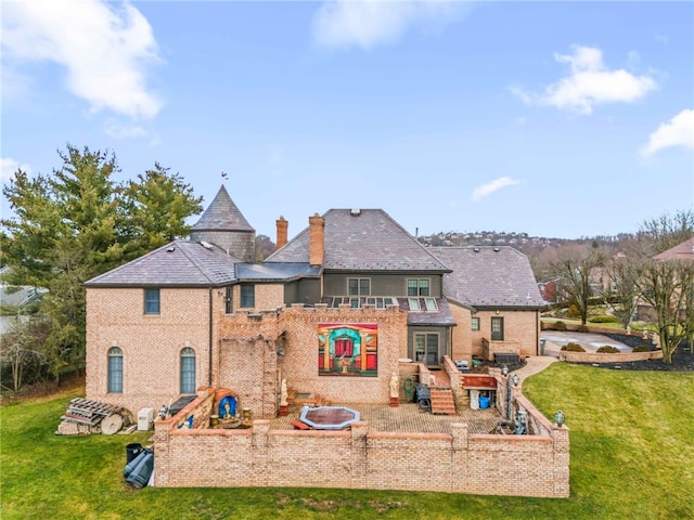 rear view of property with a lawn and a patio