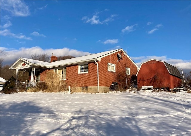 view of snow covered exterior with an outbuilding