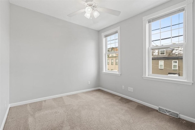 carpeted spare room with ceiling fan