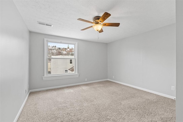 spare room featuring a textured ceiling, carpet floors, and ceiling fan