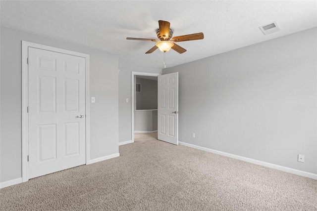 unfurnished bedroom with ceiling fan and carpet