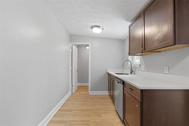 kitchen featuring dishwasher, sink, a textured ceiling, dark brown cabinets, and light hardwood / wood-style floors