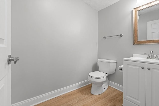 bathroom featuring hardwood / wood-style floors, vanity, a textured ceiling, and toilet