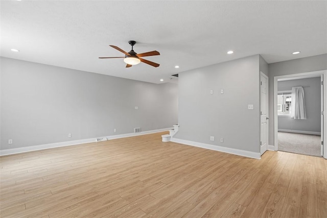 unfurnished living room featuring ceiling fan and light hardwood / wood-style flooring