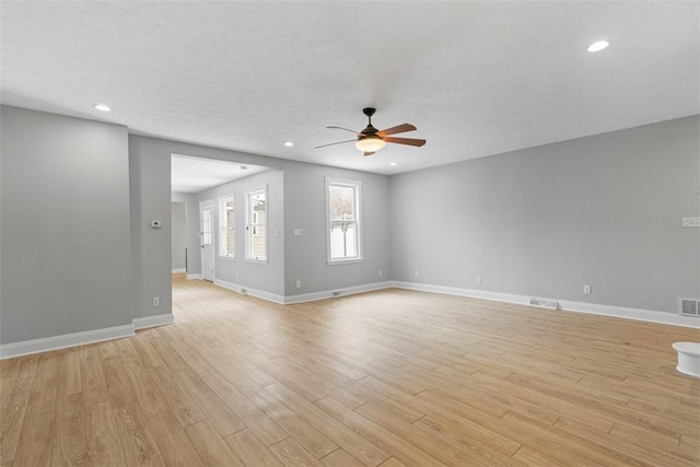 unfurnished room featuring a textured ceiling, light wood-type flooring, and ceiling fan