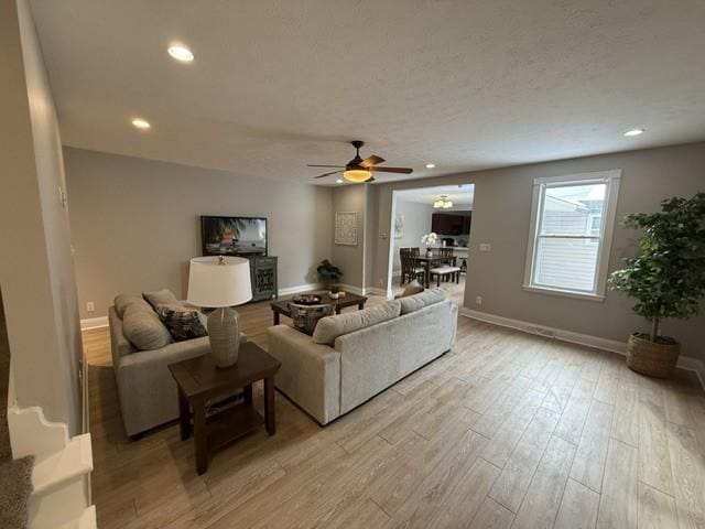 living room with ceiling fan and light wood-type flooring