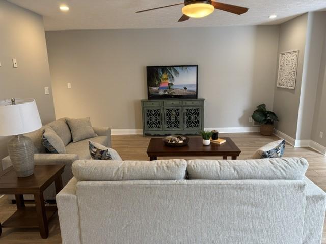 living room with hardwood / wood-style floors and ceiling fan