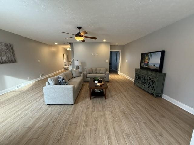 living room featuring light hardwood / wood-style floors and ceiling fan