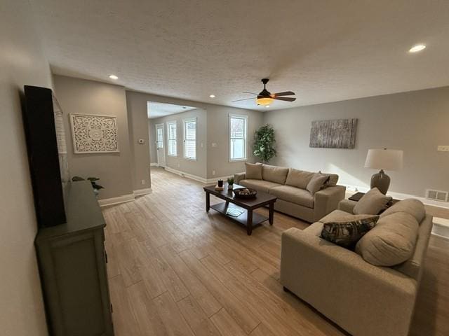 living room featuring ceiling fan and light hardwood / wood-style floors