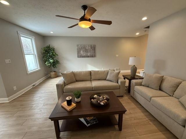 living room featuring light hardwood / wood-style floors and ceiling fan