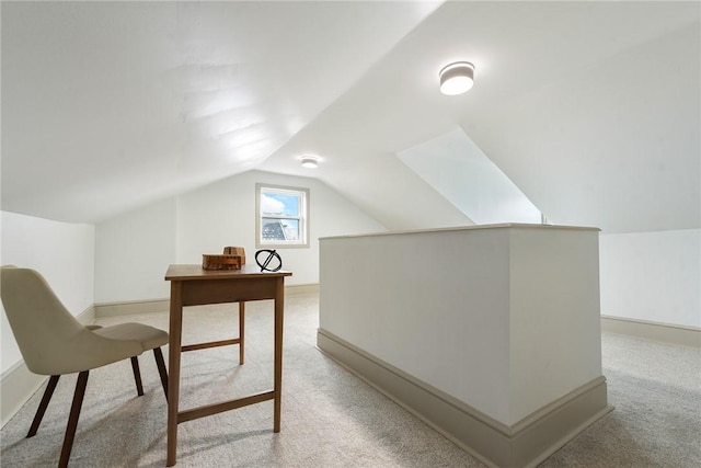 home office with light carpet and vaulted ceiling