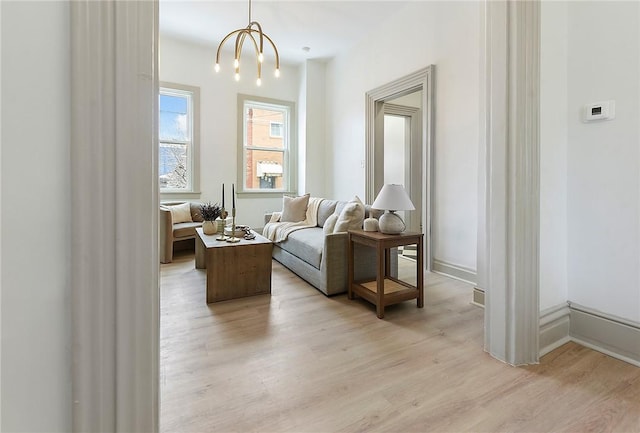 living area featuring light hardwood / wood-style floors and a notable chandelier