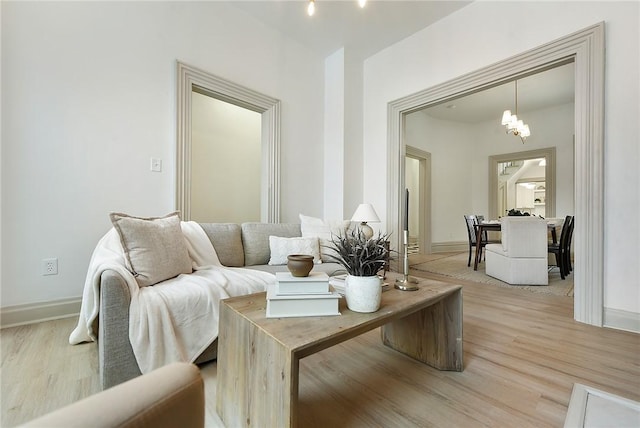 living room featuring a notable chandelier and light hardwood / wood-style flooring