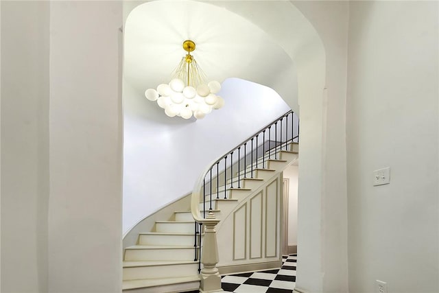 staircase featuring a chandelier