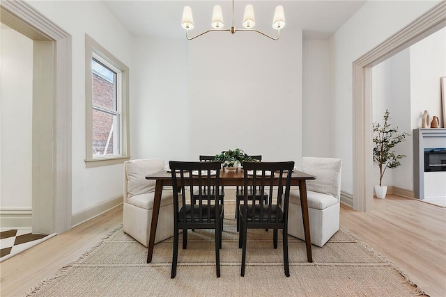 dining area featuring wood-type flooring and an inviting chandelier