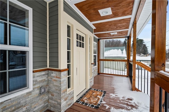 snow covered deck featuring a porch