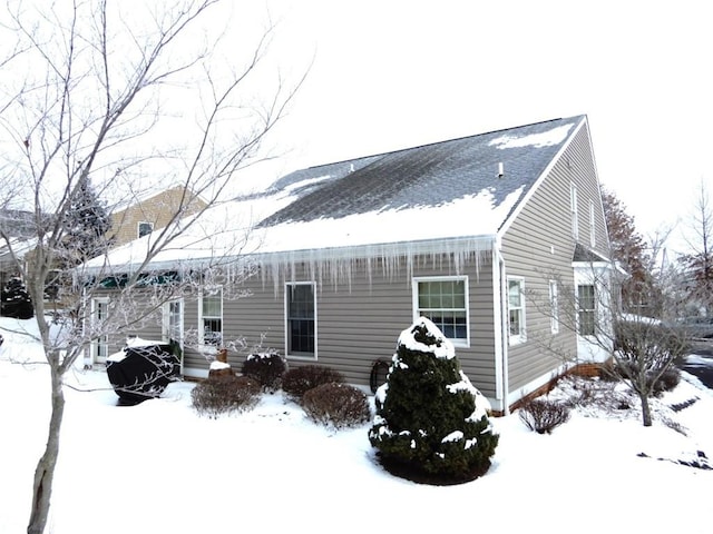 view of snow covered rear of property