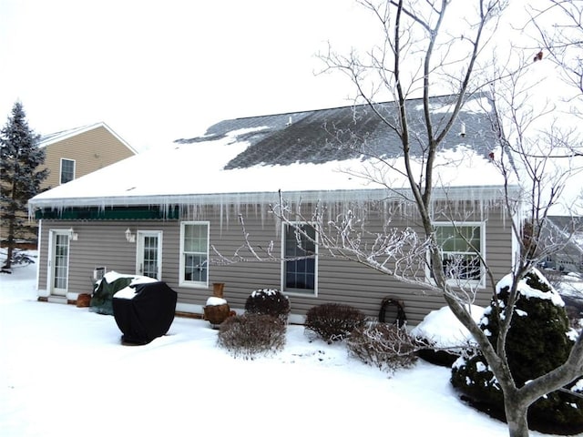 view of snow covered rear of property