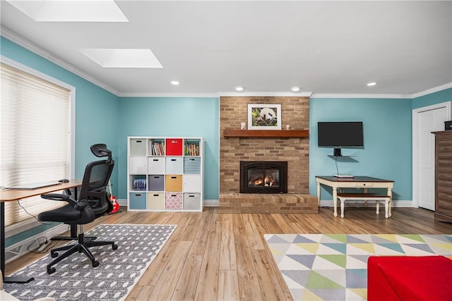 office with hardwood / wood-style floors, a skylight, ornamental molding, and a brick fireplace