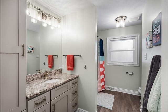 bathroom featuring vanity, hardwood / wood-style flooring, and toilet