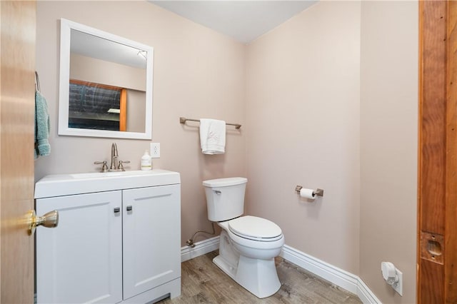 bathroom featuring hardwood / wood-style flooring, vanity, and toilet