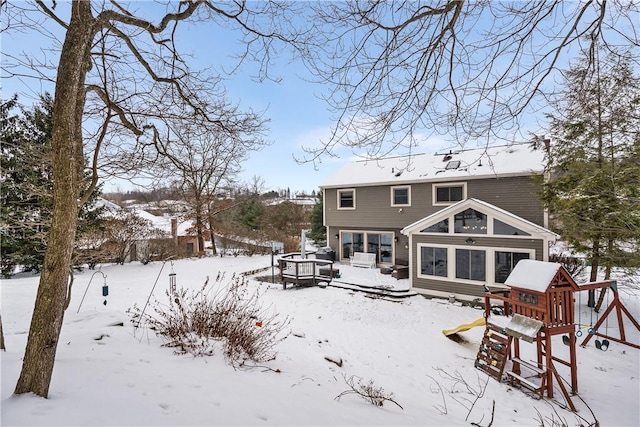 snow covered house with a playground