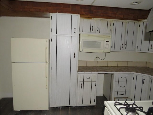 kitchen with white cabinetry, dark hardwood / wood-style flooring, and white appliances