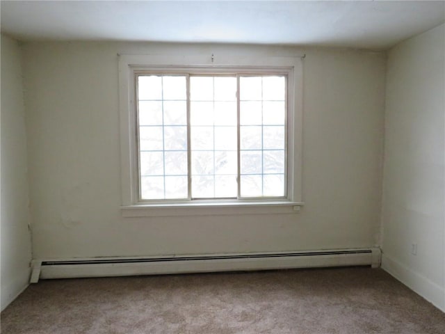 spare room featuring light carpet and baseboard heating