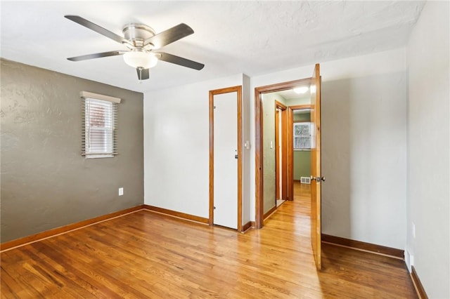 empty room with ceiling fan and light hardwood / wood-style flooring