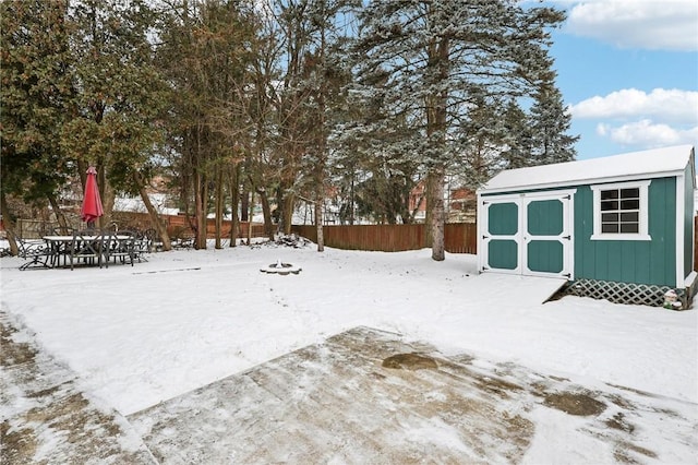 yard layered in snow with a shed