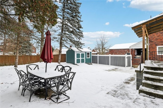 yard layered in snow featuring a shed