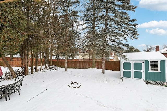 yard covered in snow featuring a storage shed