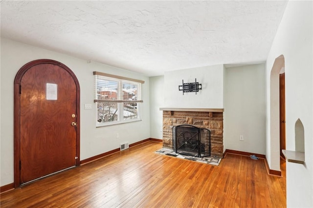 living room featuring hardwood / wood-style flooring, a fireplace, and a textured ceiling