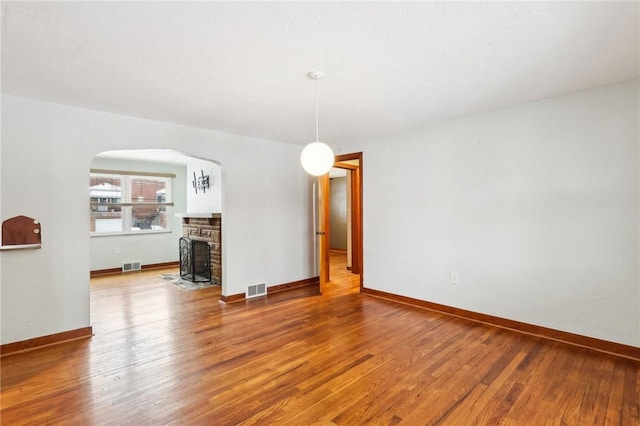 unfurnished room featuring a fireplace and hardwood / wood-style flooring