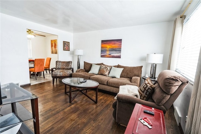 living room featuring dark hardwood / wood-style flooring, ceiling fan, and a healthy amount of sunlight