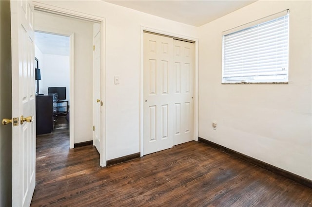 unfurnished bedroom featuring dark hardwood / wood-style floors and a closet