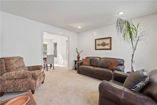 living room with light carpet and a chandelier