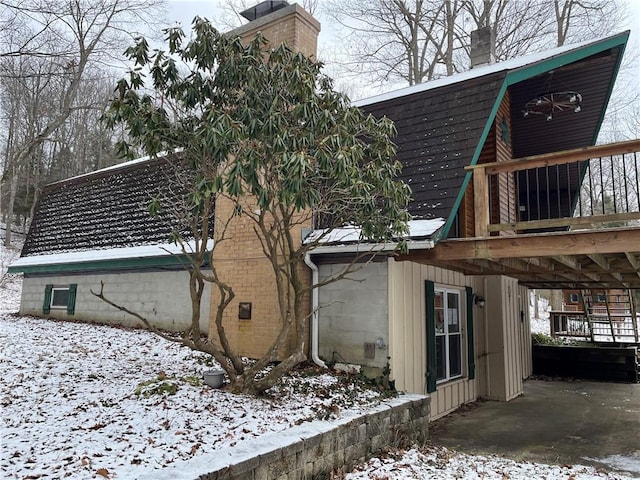 view of snow covered exterior with a deck