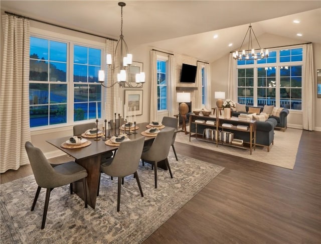 dining area with french doors, an inviting chandelier, vaulted ceiling, and dark wood-type flooring