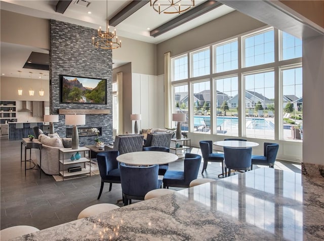 dining space featuring beamed ceiling, a notable chandelier, and a towering ceiling