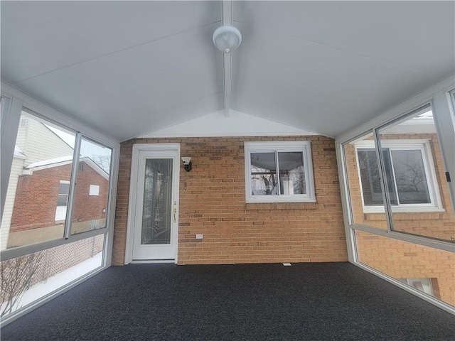 unfurnished sunroom featuring vaulted ceiling with beams