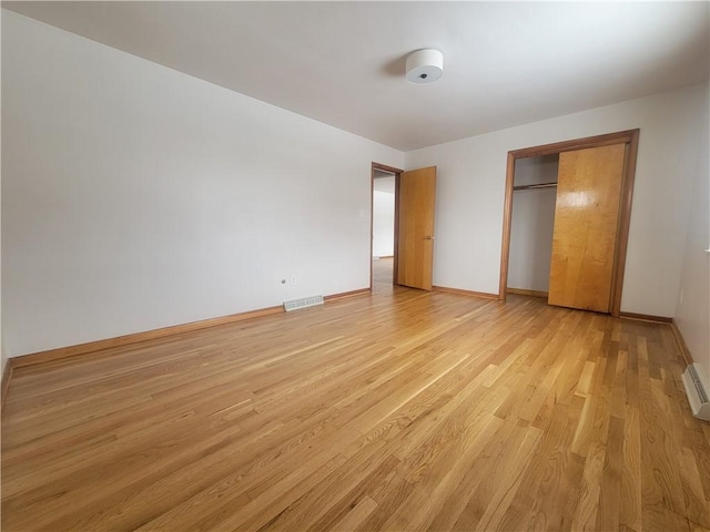 unfurnished bedroom with a closet and light wood-type flooring