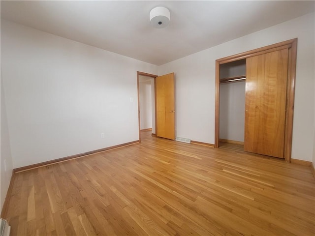 unfurnished bedroom with light hardwood / wood-style floors and a closet