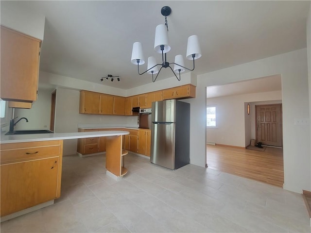 kitchen featuring pendant lighting, sink, appliances with stainless steel finishes, and an inviting chandelier