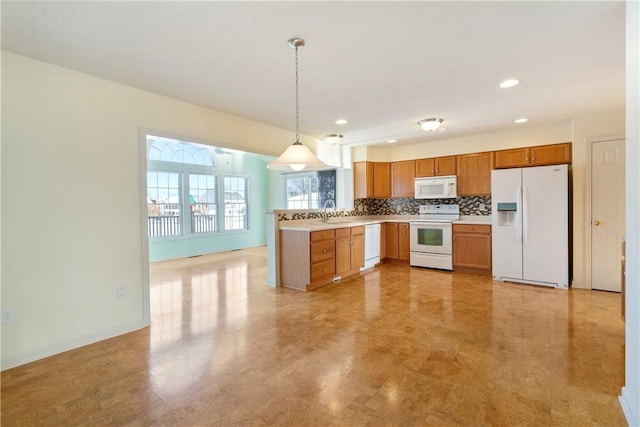 kitchen featuring decorative backsplash, pendant lighting, white appliances, and sink