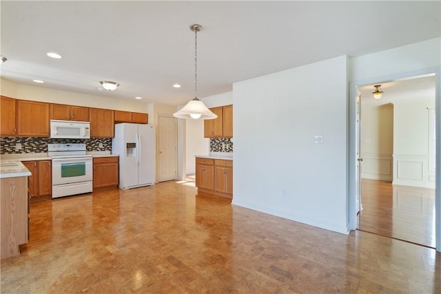 kitchen with pendant lighting, white appliances, and tasteful backsplash