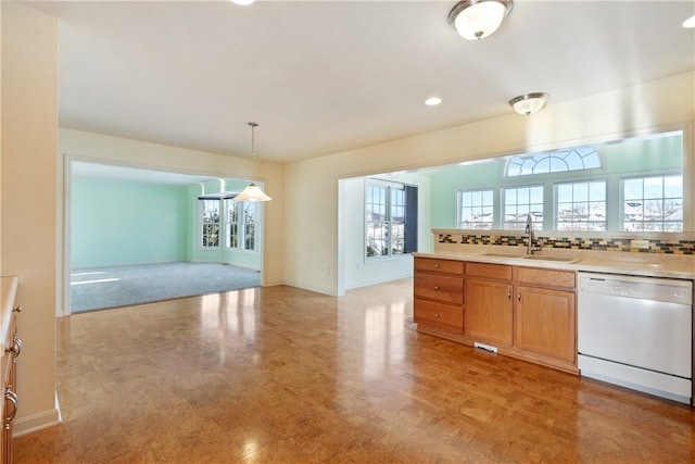 kitchen with dishwasher, sink, hanging light fixtures, plenty of natural light, and decorative backsplash