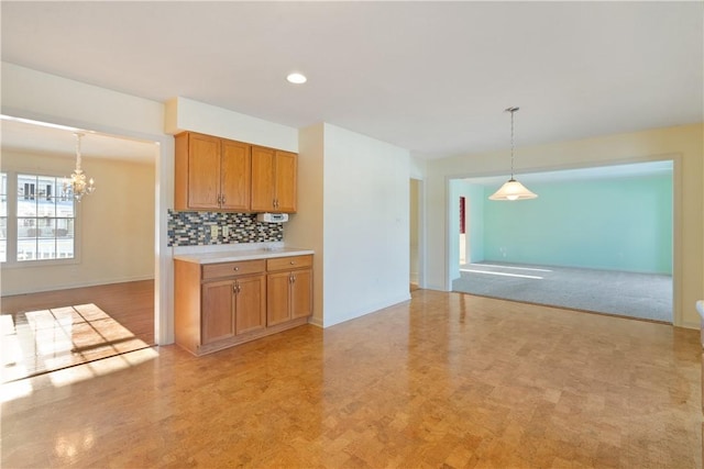 kitchen featuring pendant lighting, a notable chandelier, and backsplash