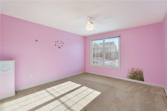 carpeted spare room featuring ceiling fan