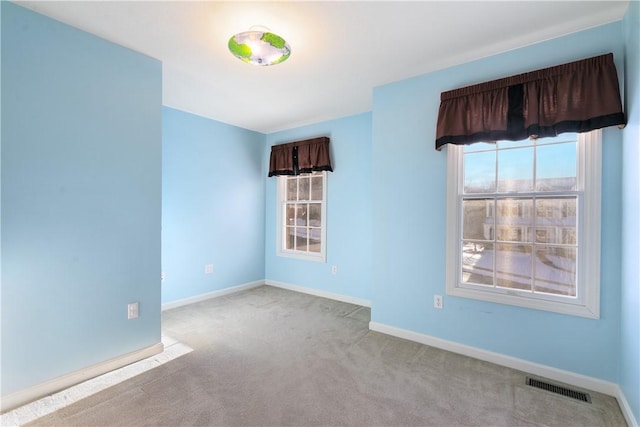 unfurnished room featuring light carpet